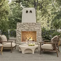 Outdoor Stone Fireplace With Burning Fire Rattan Chairs And Coffee Table In Garden