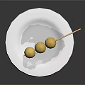 Three Yellow Balls Skewered On Bamboo Stick Served On White Plate With White Sauce