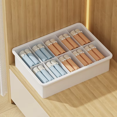 Neatly Folded Colorful Clothes Organized in White Storage Box with Multiple Compartments on Wooden Cabinet 3d model