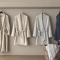 Cozy Bathrobes Hanging On Wall In Neutral And Dark Blue With Wicker Basket Holding Towels
