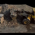 Yellow Loader Near Large Gravel Pile With Stone Blocks At Construction Site