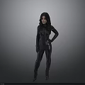 Woman In Black Tight Fitting Suit Standing With Hands On Hip Against Gray Gradient Background
