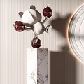 Silver And White Sculptures With Red Pink Balls On Marble Pedestal And Circular Wall Decor