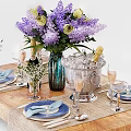 Elegant Tableware Set with Blue Napkins Plates Wine Glasses and Purple Flowers on Wooden Table