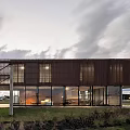 Modern Detached Villa Exterior With Corrugated Metal Cladding Large Glass Windows And Landscaped Grass Area