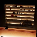 Modern Commercial Equipment with Wooden Wine Racks Various Bottles Wine Glasses and Orange Counter