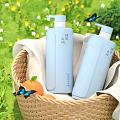 Light Blue Liquid Soap Bottles in Wicker Basket with White Cloth Grass Flowers and Butterflies