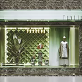 Shop Window Display With Quilted Green Wall Mannequin Dress Green Plant And Decorative Lighting
