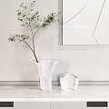 White Ceramic Vase With Green Branches And Smaller Vase On Light Wall With Geometric Painting
