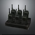 Multiple Black Walkie Talkies Charging On Desktop Dock Station For Communication