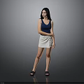 Woman In Blue Tank Top And Beige Skirt Standing With Black Sandals On Gray Background