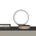 Modern Spherical White Table Lamp With Silver Base On White Tabletop