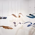 Abstract Wave Shaped Pendant Lights With Metallic Finishes In Blue Gold Brown Tones Hanging