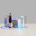Woman In Black Dress At Opening Display With Illuminated Letters Colorful Pillars Spheres And Blue Light Circle