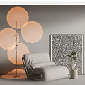 Single Sofa with Floor Lamp Circular Lampshades Black White Patterned Painting and Small Potted Plant