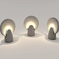 Three Gray Outdoor Lights with Stone Base and Round Shade Illuminated with Soft Glow