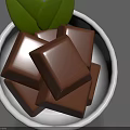 Fresh Chocolate Pieces in White Bowl Topped with Green Leaves
