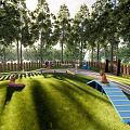 Wooded Surroundings Circular Fenced Children's Playground With Track Slides Swings Green Lawn And Gray Path