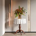 Corner Table With White Lace Tablecloth Vase Red Flowers Green Leaves Wooden Legs Golden Lights