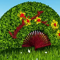 Green Fan Shaped Decorative Bush With Red Yellow Flowers In Grass Field
