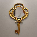 Golden Key Shaped Decorative Mirror With Ornate Frame Hanging On Gray Wall