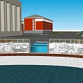 Red Multi Story Building With Circular Pool And Surrounding Structures Under Blue Sky