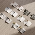 Scattered Open Books And Magazines On Wooden Floor With Black And White Photos And Text