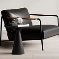 Modern Black Leather Accent Chair With Wooden Armrests Side Table Books And Decorative Object