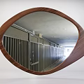 Oval Wooden Frame Mirror Reflecting Interior Corridor With Metal Railings And Ceiling