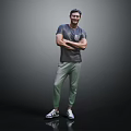 Smiling Man in Gray T Shirt and Green Pants with Arms Crossed Against Gray Background