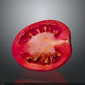 Fresh Halved Tomato with Red Juicy Flesh Seeds and Central Core on Dark Surface