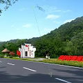 Garden Ornament with Mini House Structure and HELLO Sign on Green Grassland Under Blue Sky