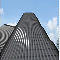 Modern Tall Office Building With Glass Curtain Wall And Blue Sky Background