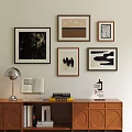 Stylish Photo Wall With Framed Artworks Above Wooden Cabinet Table Lamp Books And Decorative Object