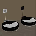 White And Black Robot Vacuum Cleaners Charging Against Wall In Modern Home