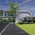 Modern White Building with Curved Roof Large Glass Windows Green Trees Lawn and Black Driveway