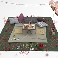 Romantic Outdoor Setup With Green Blanket Pillows Rose Petals Balloons And I Love You Lettering