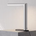Modern Desk Lamp With Aluminum Pole Black Base Simple Design On Table Against White Wall