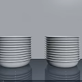 Decorative Ornament Set with Stacked White Plates on Gray Countertop Light Gray Background and Reflections