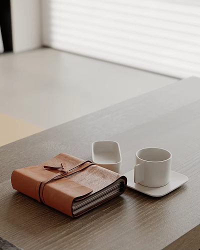 Decorative Ornament Set with Leather Notebook White Cup Saucer Small White Container on Wooden Tabletop 3d model