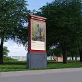Outdoor Billboard Featuring Sculpture Painting In Park With Green Trees And Grass