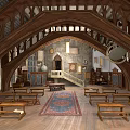 Medieval Architectural Interior With Arched Wooden Roof Trusses Stone Walls And Wooden Benches