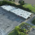 Spacious Commercial Parking Lot With Parked Cars And Green Surrounding Trees