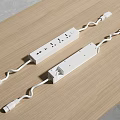Two White Power Strips with Multiple Outlets and Curved Cords on Wooden Table 3d model
