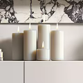 Decorative Ornament Set With Lit Candles Stacked Books And Marble Wall Backdrop On White Cabinet