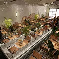 Modern Restaurant Interior With Wooden Tables Green Plants And Hanging Lights