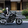 Stylish Motorcycle With Silver Haired Woman In Black Outfit Near Modern House And Green Plants