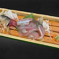 Fresh Fish Sashimi Slices in Wooden Box with Shiso Leaves Daikon Shreds and Wasabi