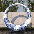 Garden Landscape With Blue and White Circular Sculpture Floral Patterns Stone Wall and Water Surface