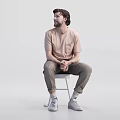 Two Men Sitting on White Stools Wearing Beige T-Shirts and Khaki Pants